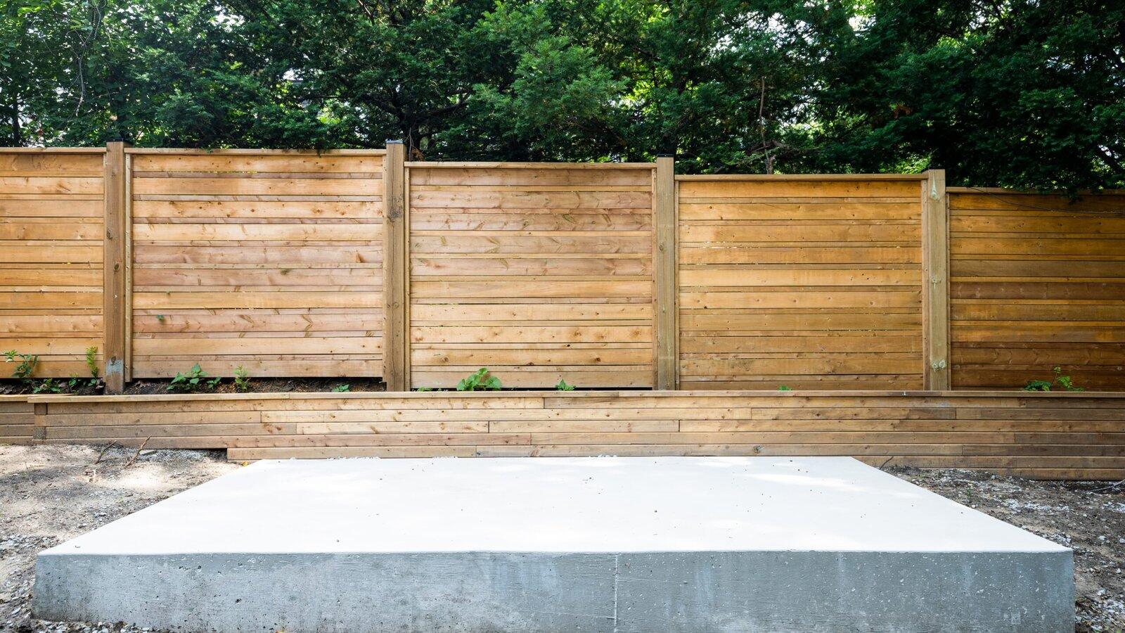 Concrete pad, fence, and retaining wall in The Kingsway